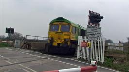 An engine with no coaches crosses the Level Crossing at Athelney